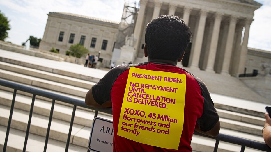 A protester waits outside the U.S. Supreme Court building for its decision on President Bidens student loan forgiveness program